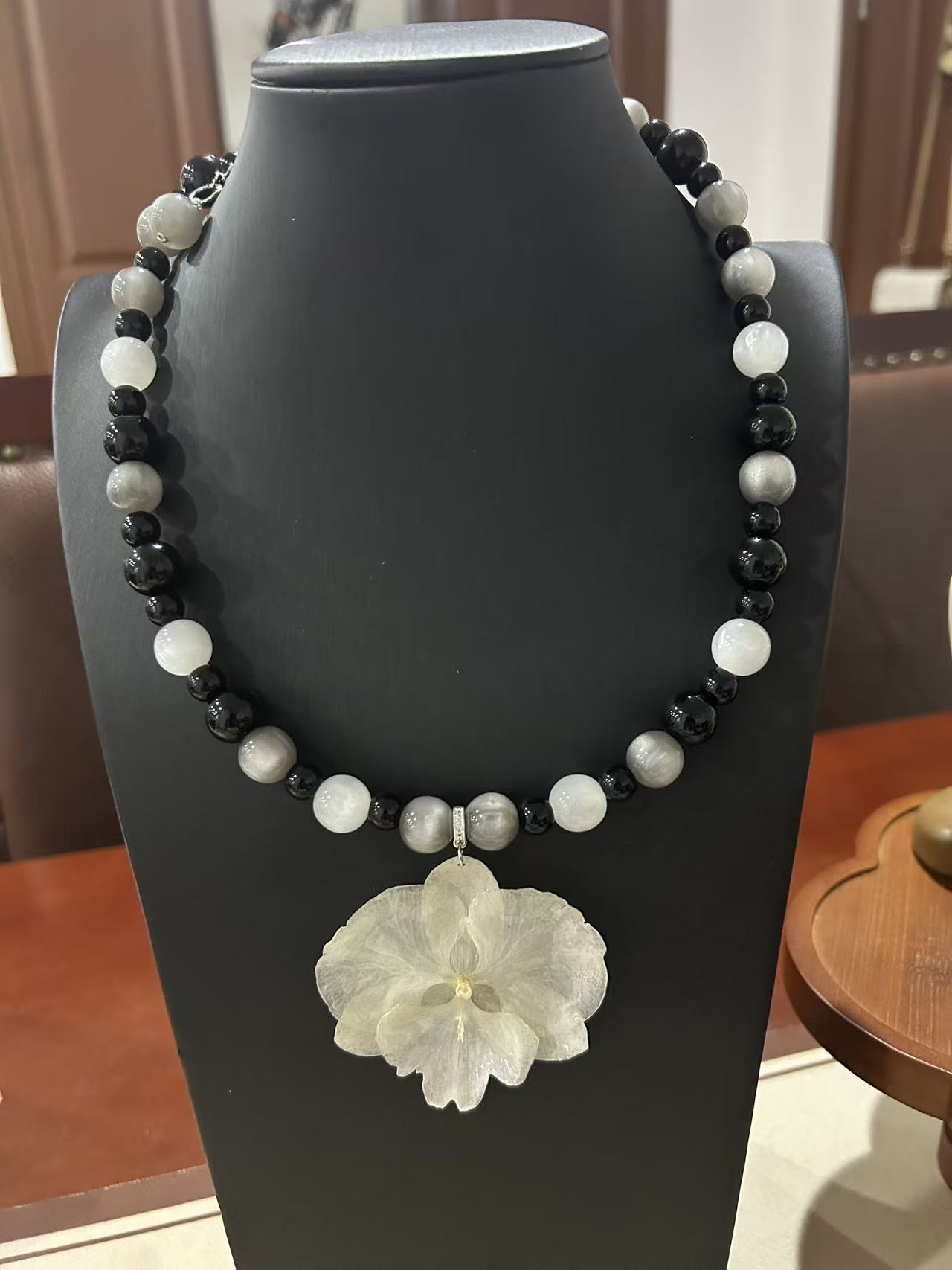 White orchid with black and white beaded necklace