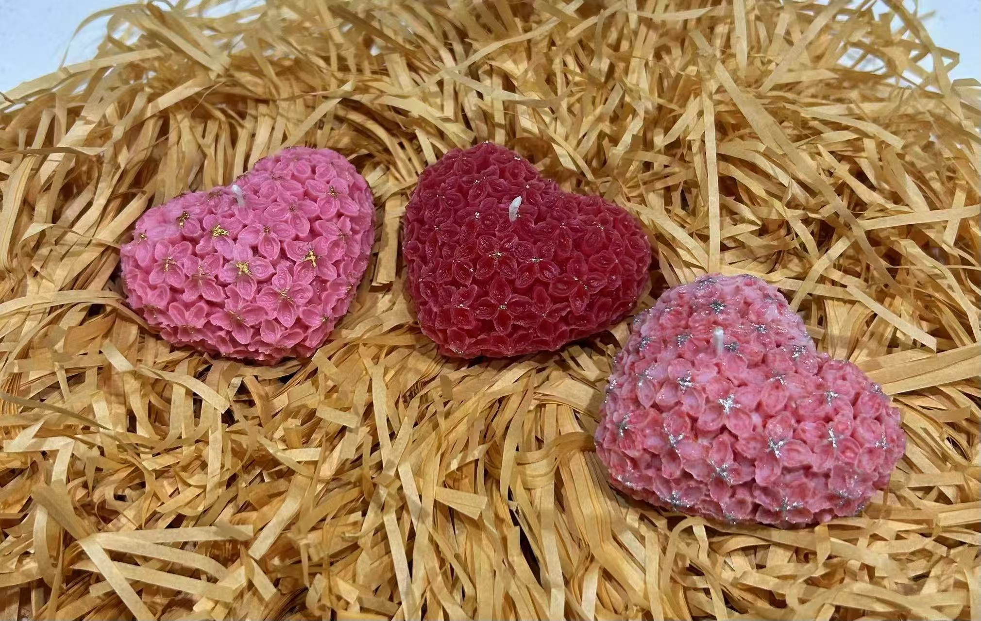 Three rose-covered heart candles