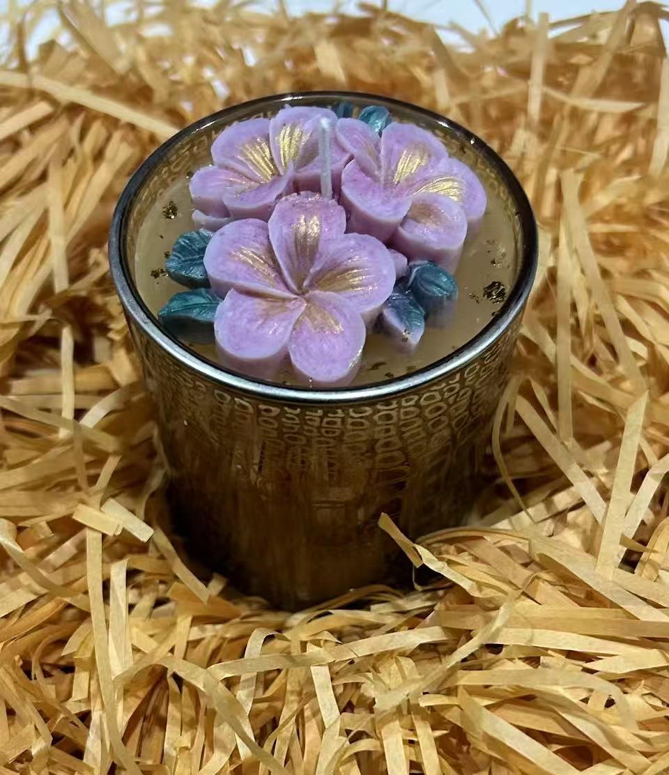 Purple floral candle in a decorative vessel