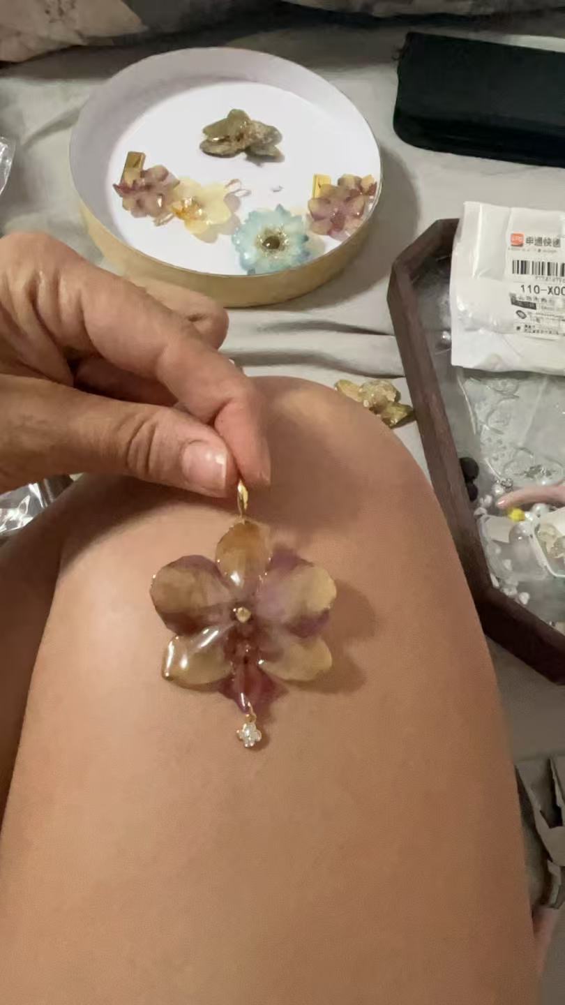 Sarai adding jewelry findings to a preserved flower