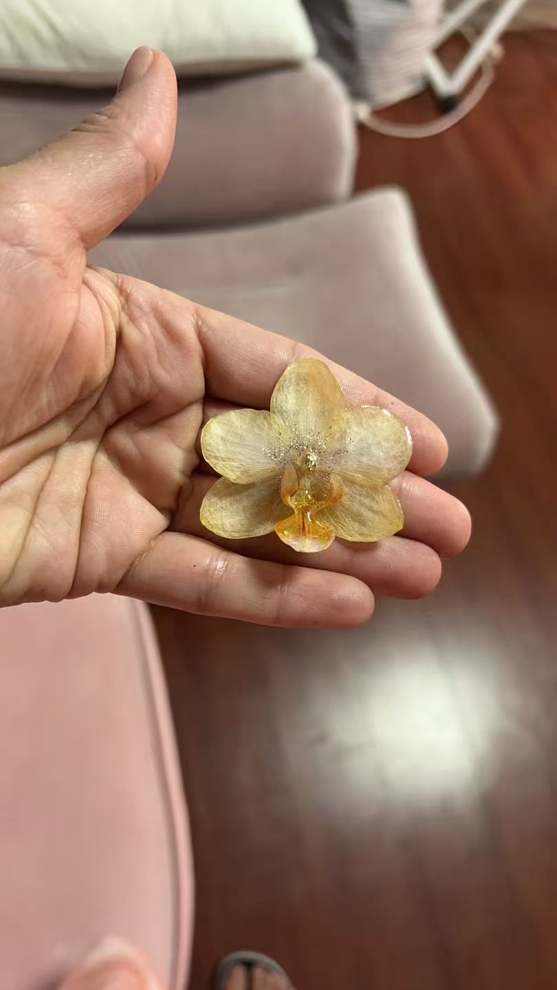 Gold preserved orchid held in hand
